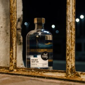 Berlin Distillery Berliner Nacht Gin bei Nacht zwischen zwei Stangen eines Geländers